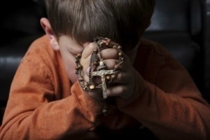 niño rezando el rosario